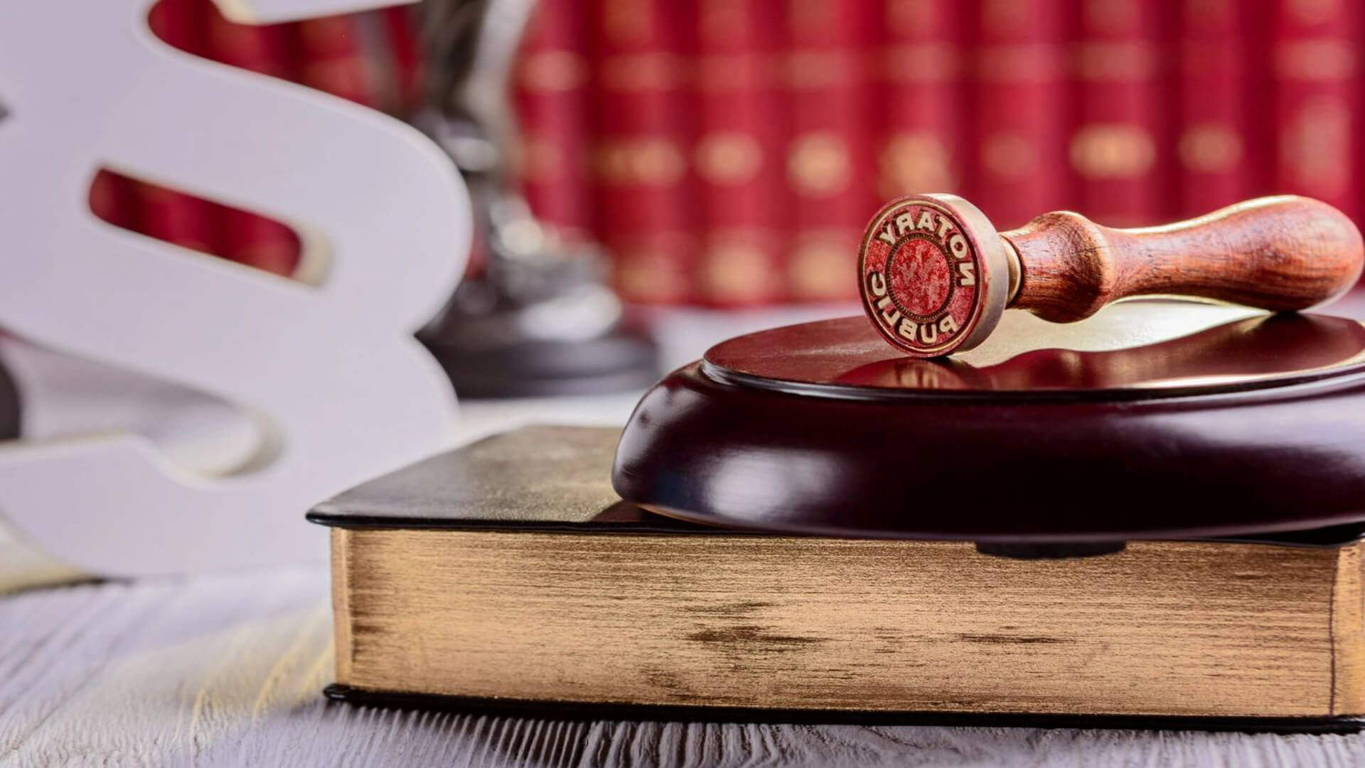 A wooden gavel sitting on top of an old book.